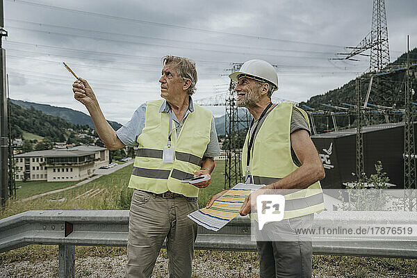 Senior engineer talking with coworker at power station