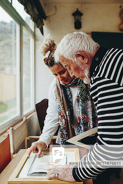 Senior man and woman examining painting at home
