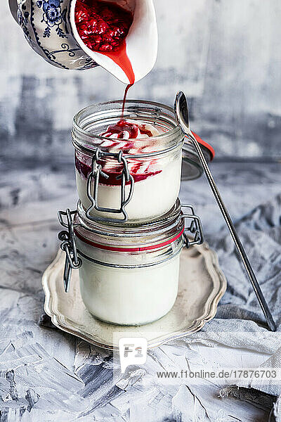 Raspberry topping pouring on homemade frozen yogurt