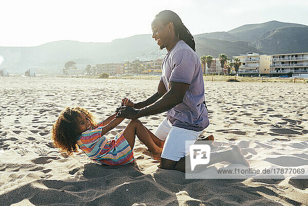 Vater spielt mit Tochter am Strand