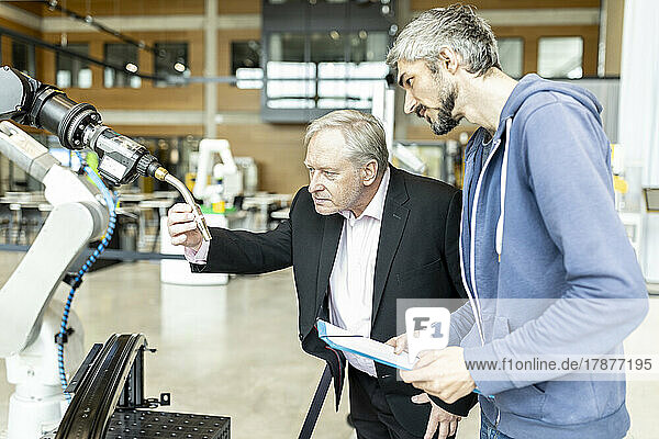 Senior customer getting advise on industrial robot from expert staff