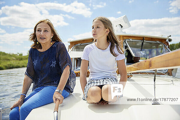 Girl talking with grandmother sitting on boat deck