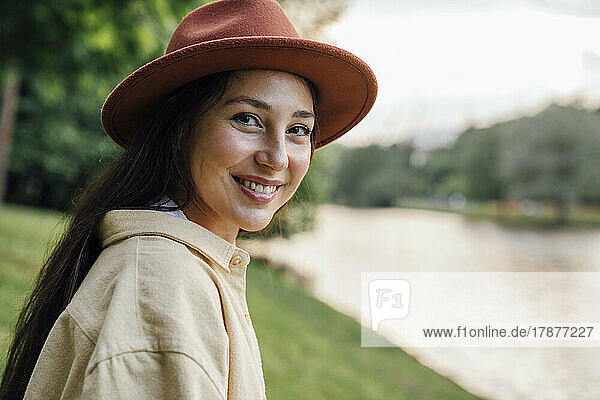 Happy woman wearing hat at park