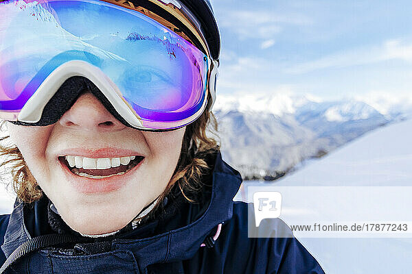 Glückliche Frau  die im Winter eine Skibrille trägt