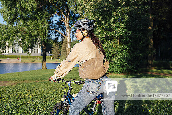 Woman riding bicycle at park on sunny day