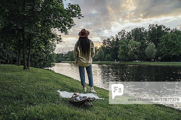 Woman standing and looking at sunset in park