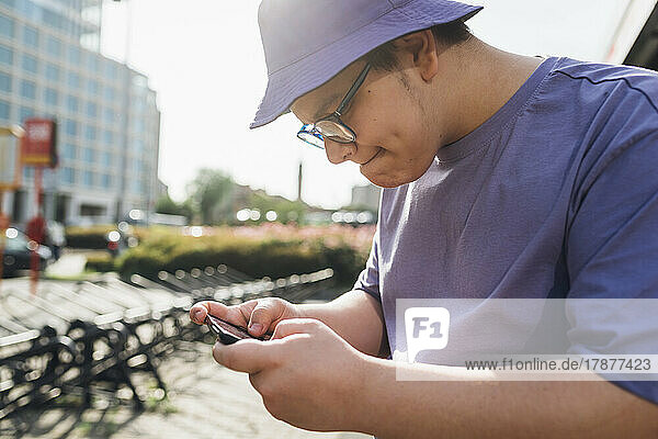 Determined teenage boy playing video game on mobile phone