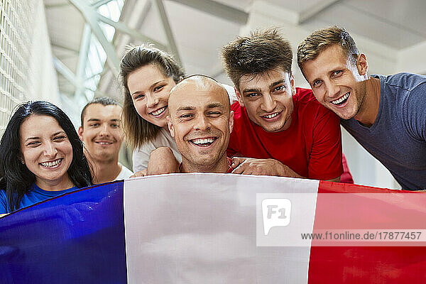Happy sports fans with French Flag in stadium