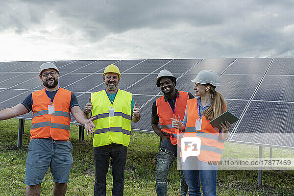 Happy engineers standing together at solar power station