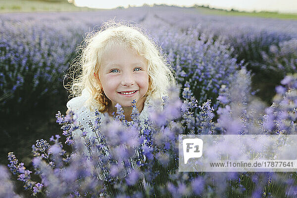 Smiling girl with blond hair amidst lavender plants