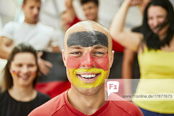 Happy man with German Flag painted on face at stadium