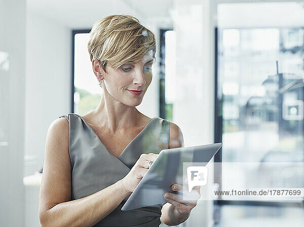 Blond businesswoman using tablet PC in office