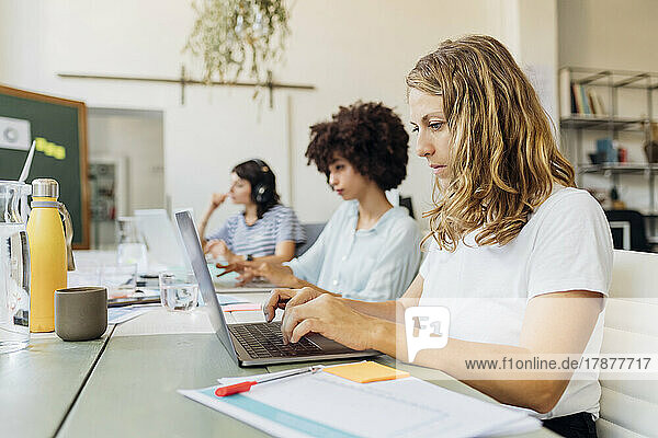 Blond businesswoman working on laptop in office