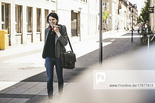 Smiling young transgender businesswoman talking on phone