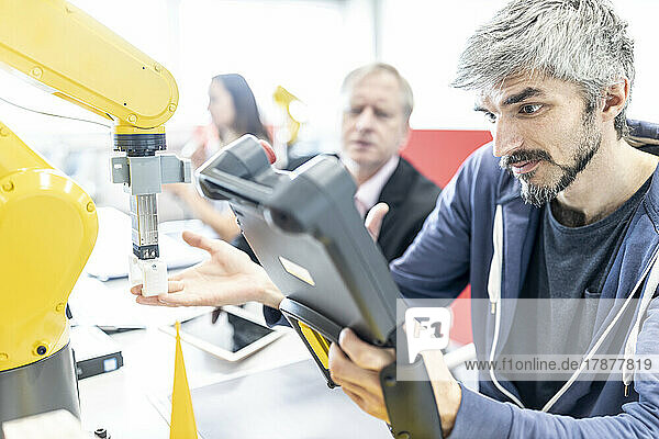 Industrial engineer working at industrial robot using digital control