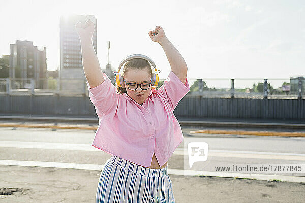 Teenager-Mädchen trägt Kopfhörer und tanzt auf der Straße
