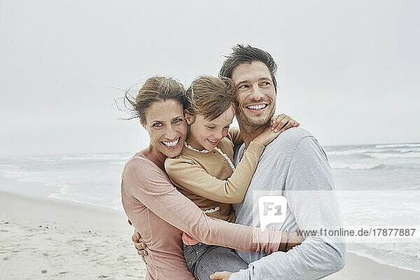 Carefree family with daughter on the beach