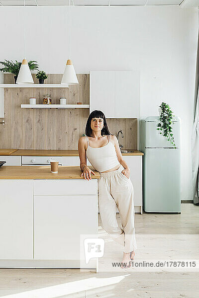 Woman leaning on kitchen island at home