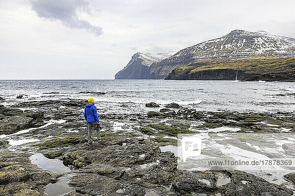 Faroe Islands  Eysturoy  Eidi  Male hiker admiring coastal landscape
