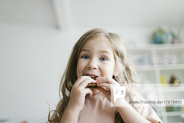 Girl (2-3) eating snack