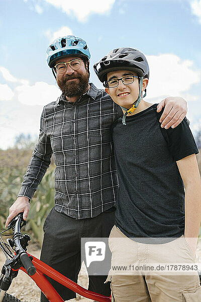 Portrait of father and son (14-15) in bike helmets