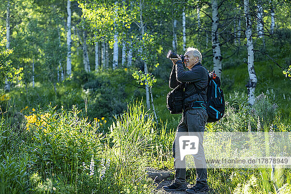 United States  Idaho  Senior man photographing while hiking in Sun Valley