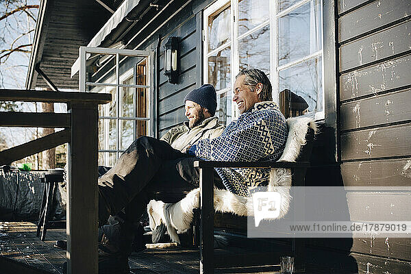 Glückliche reife Freunde sitzen im Winter auf der Veranda zusammen