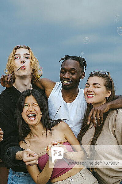 Glücklich multirassische männliche und weibliche Freunde haben Spaß zusammen gegen den Himmel