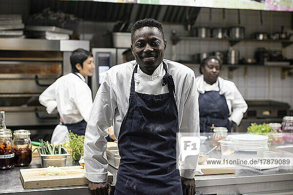 Portrait of smiling chef standing in restaurant kitchen