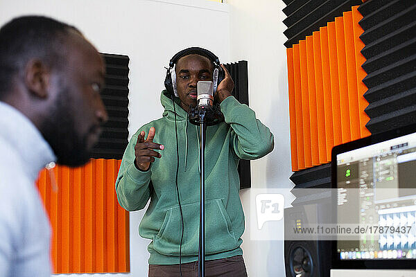 Rapper und Tontechniker bei der Aufnahme eines Songs im Studio