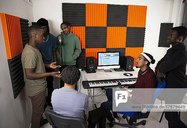 Ein Team von Musikern diskutiert in einem Aufnahmestudio