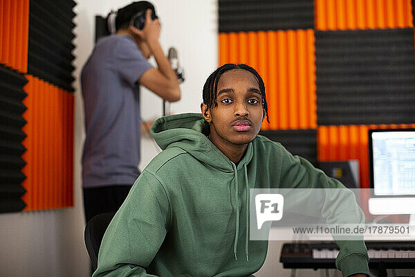 Teenage boy with dreads sitting in recording studio