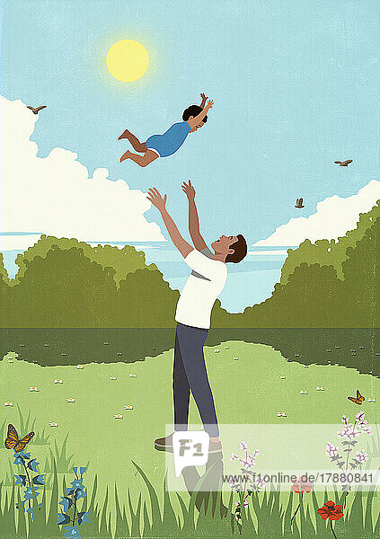 Father throwing playful son overhead in sunny  idyllic meadow
