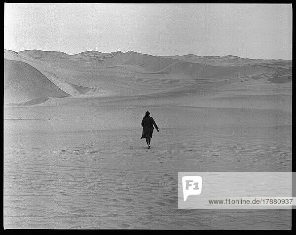 Woman walking in sandy desert  Huacachina  Lima  Peru