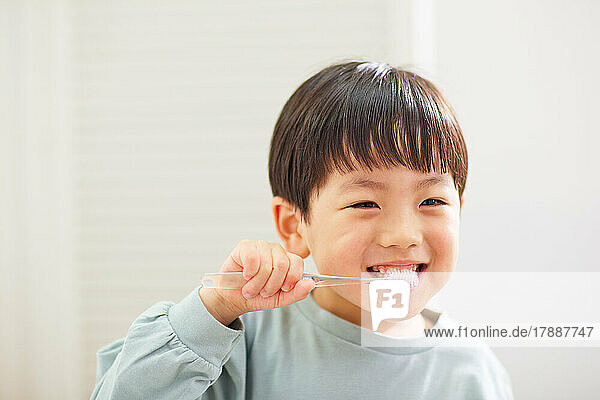 Japanese kid brushing teeth at home