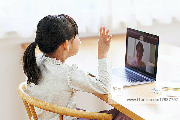 Japanisches Kind führt Videogespräch mit Laptop