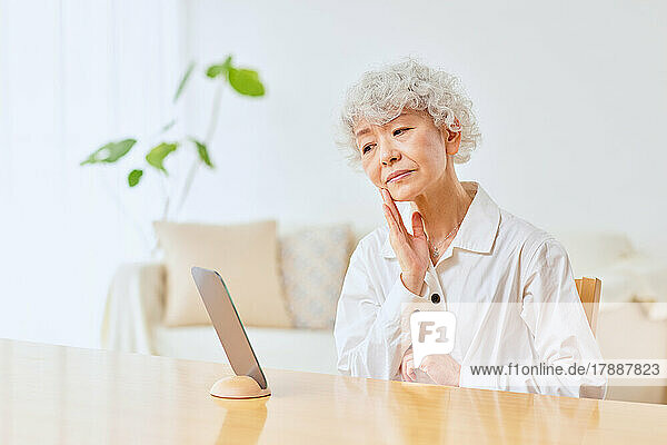 Japanische Seniorin bei der Hautpflege zu Hause