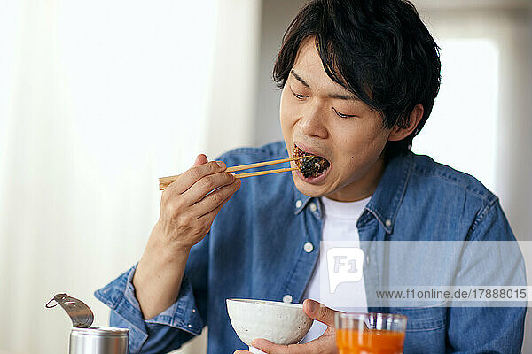 Japanischer Mann beim Essen zu Hause