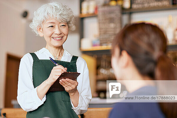Japanische ältere Frau arbeitet in einem Restaurant
