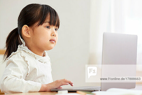 Japanisches Kind benutzt Laptop