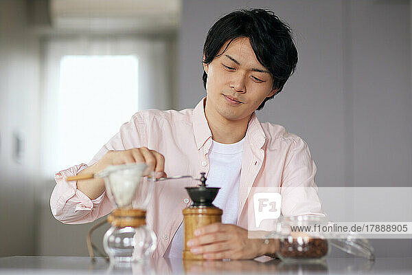 Japanese man grinding coffee at home