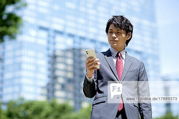 Japanischer Geschäftsmann mit Smartphone