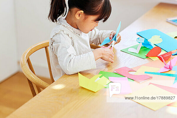Japanese kid playing with origami at home