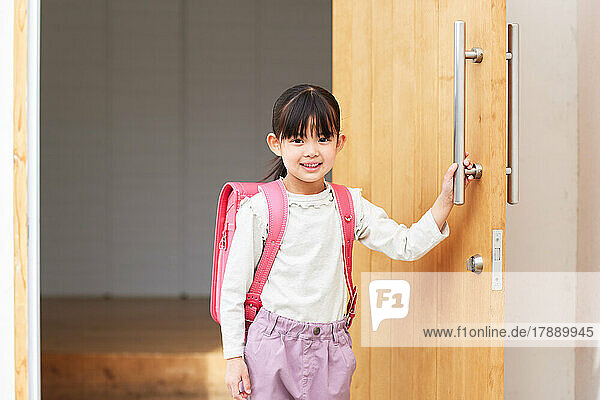 Japanisches Kind verlässt sein Zuhause  um zur Schule zu gehen
