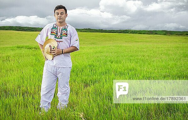 Nicaraguan man in folk costume in the field  Man wearing Central American folk costume. Young man in cultural and folk costume from Nicaragua. Concept of man in Nicaraguan folk costume