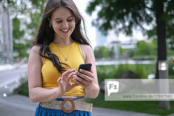 Young woman using smart phone at park