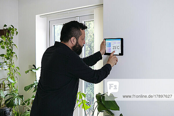 Reifer Mann regelt die Temperatur zu Hause über einen Tablet-PC