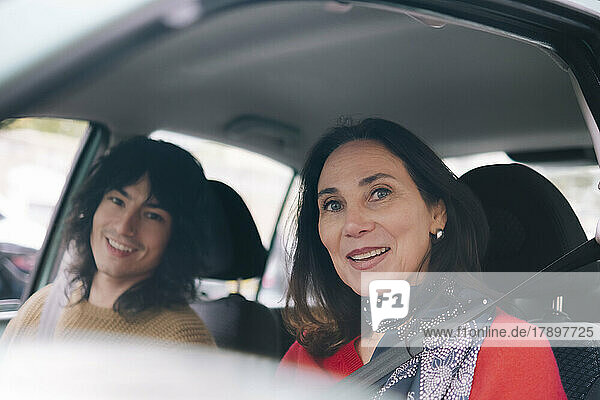 Happy mother and son traveling in car