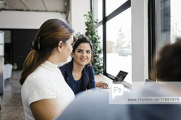 Businesswoman sharing ideas with colleagues in office