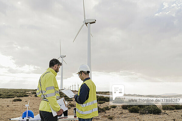 Engineer discussing with colleague at wind farm